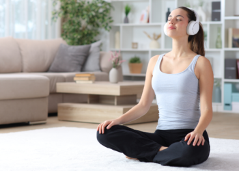 young woman meditating while listening to relaxing music