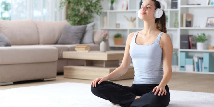 young woman meditating while listening to relaxing music